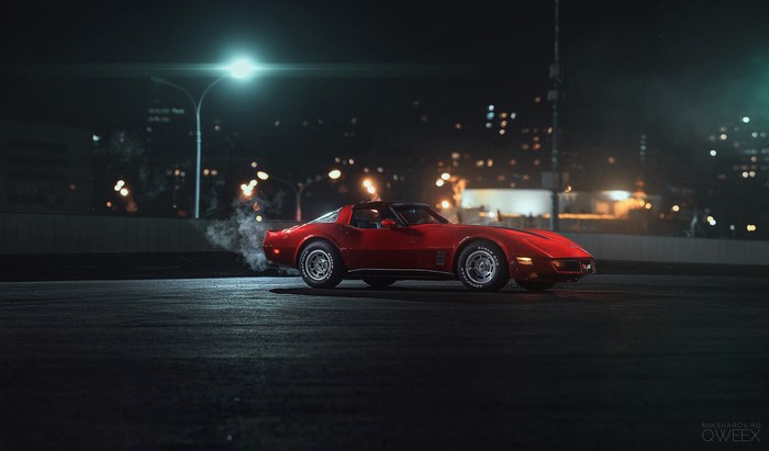 Red Chevrolet Corvette C3 at night with smoke