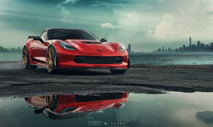 Red Chevrolet Corvette C7 parked by the water with city skyline