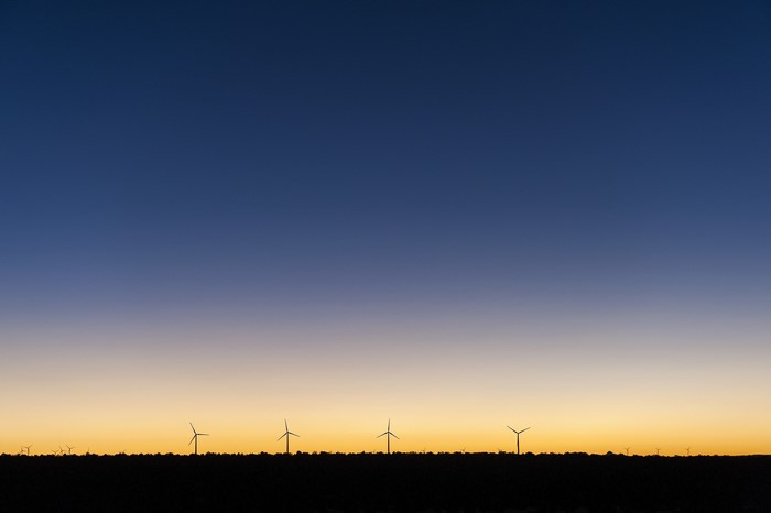 Wind farm silhouette against a sunset sky