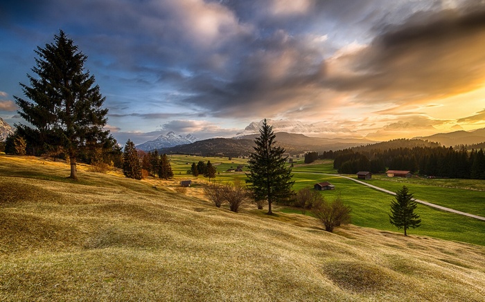 Mountain landscape with rolling hills and trees at sunset
