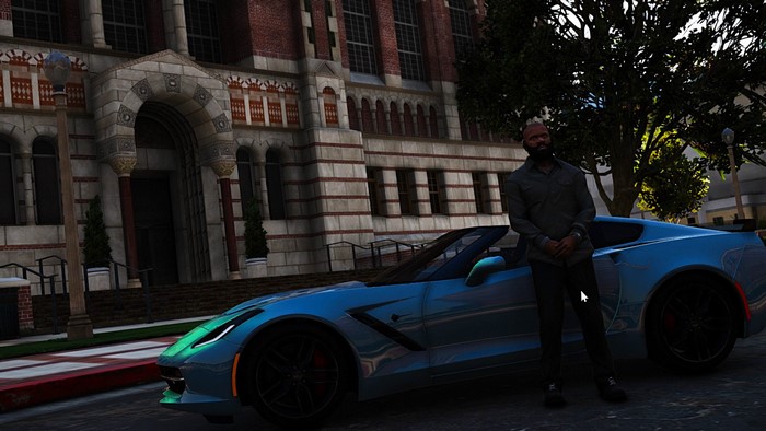 Man standing next to a blue sports car in front of a building