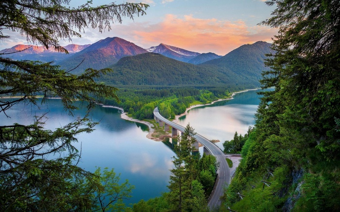 Bridge over a lake with mountains and trees