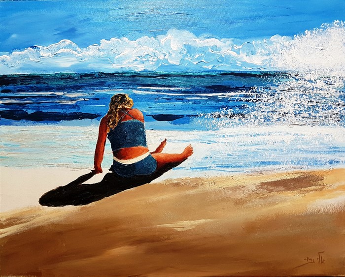 Girl sitting on a beach watching the waves