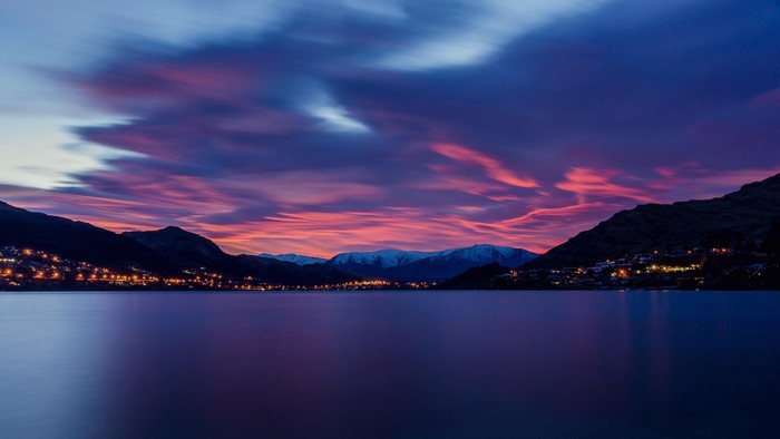 Lake and mountains at dawn with purple sky