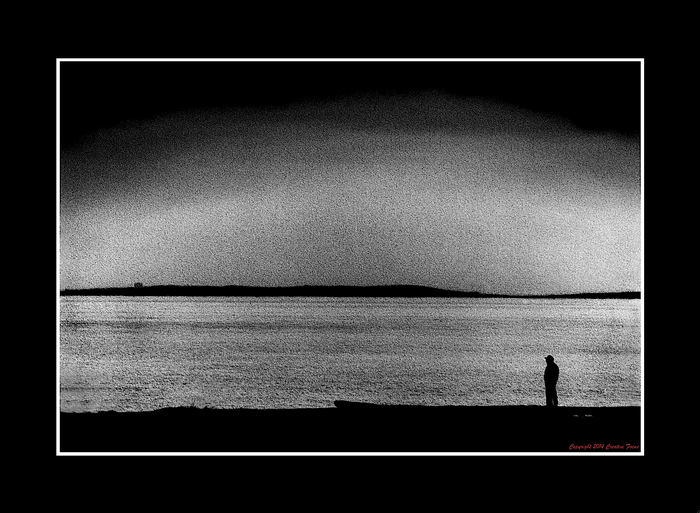 Silhouette of a person by the water