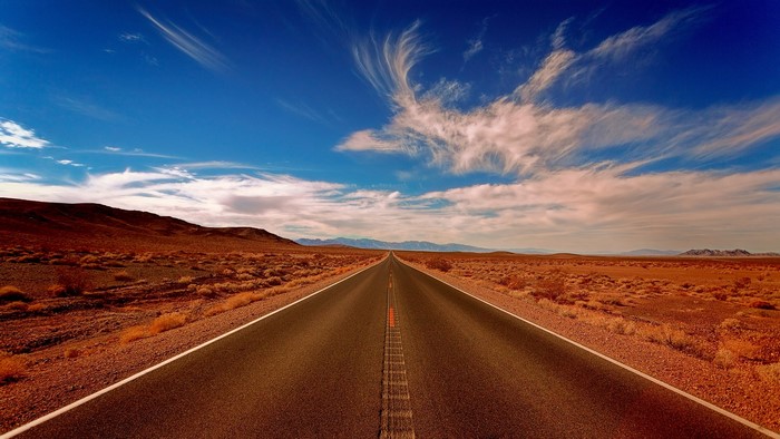 Desert road with mountains and blue sky