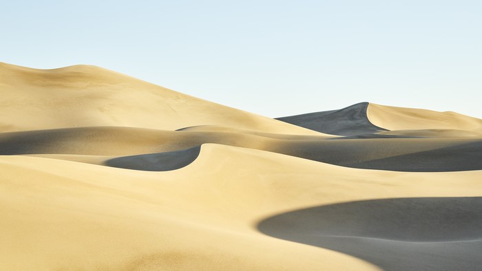 Desert sand dunes under a clear sky