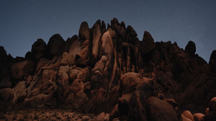 Rocky desert landscape under a starry night sky