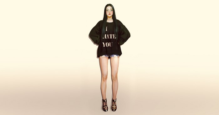 Woman wearing a black sweatshirt with text and denim shorts