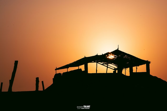Silhouette of a hut at sunset