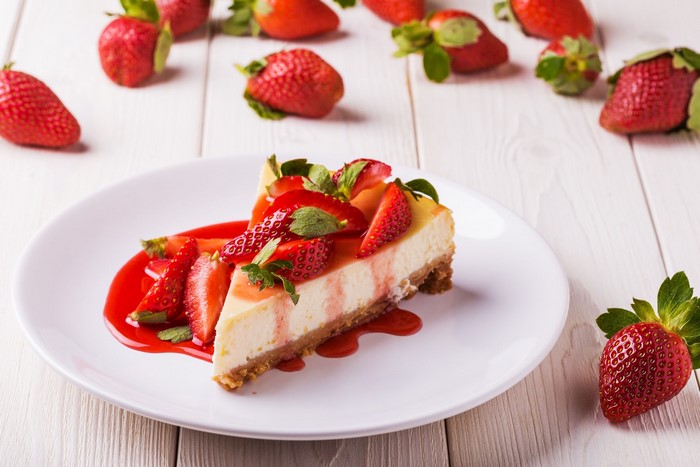 Slice of strawberry cheesecake with fresh strawberries