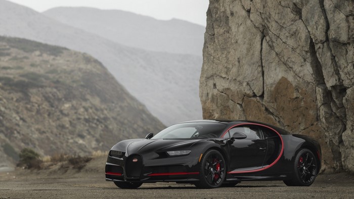 Black Bugatti Chiron parked near a rock formation