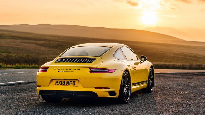 Yellow Porsche 911 Carrera T on a road at sunset