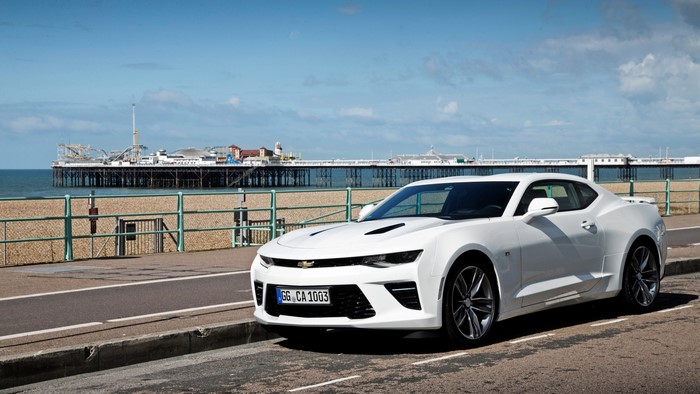 White Chevrolet Camaro parked by a pier