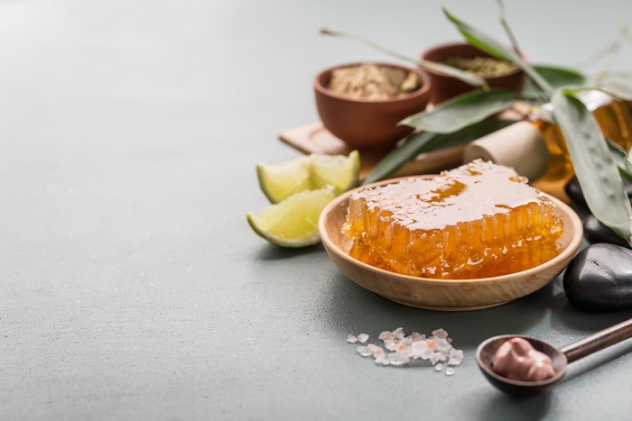 Honeycomb, limes, and spa ingredients on a table