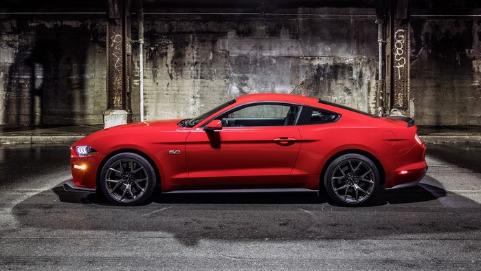 Red Ford Mustang GT parked under a bridge