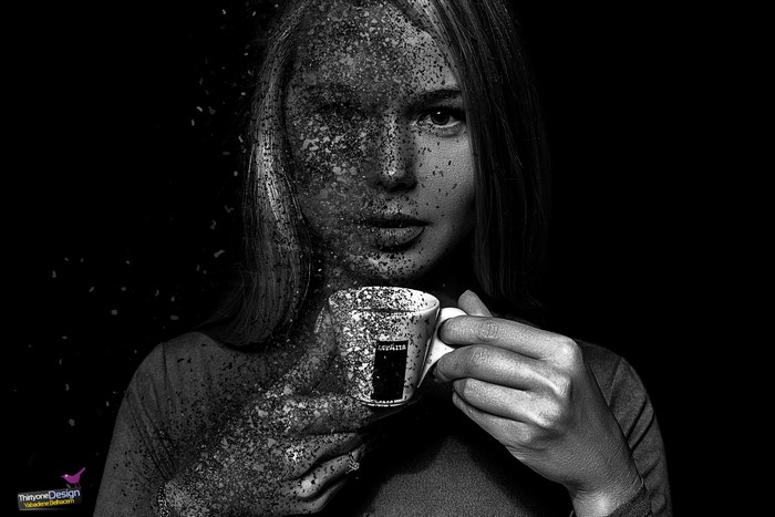 Woman with coffee cup dissolving into particles