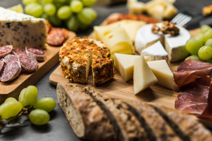 Cheese and meat platter with bread and grapes