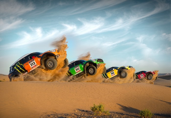 Off-road race cars jumping over sand dunes