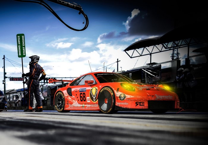 Porsche 911 race car with driver and pit crew