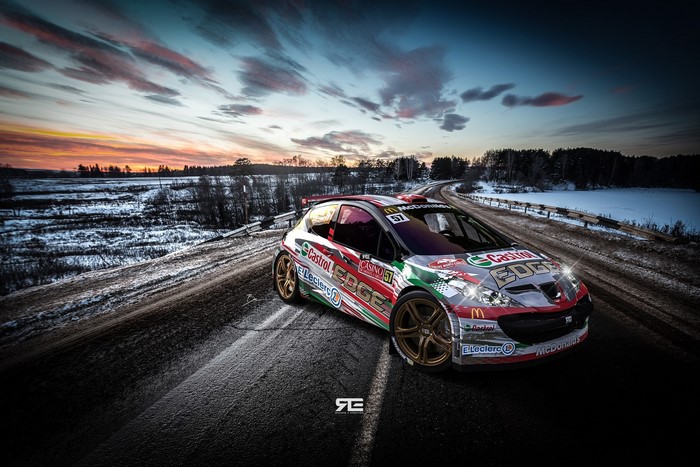 Peugeot rally car on a snowy road at sunset
