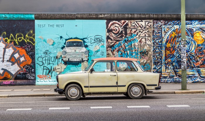 Trabant car parked by the Berlin Wall graffiti