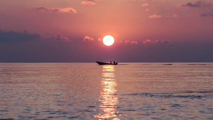 Boat sailing on the sea at sunset