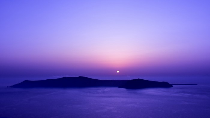 Island silhouette at sunset over the ocean