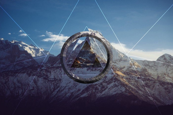 Geometric shapes overlaying snowy mountains under a blue sky