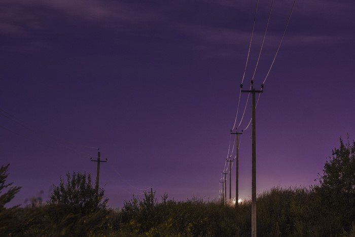 Power lines against a purple night sky