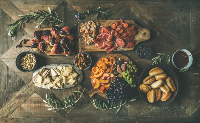 Charcuterie board with figs, meats, cheese, fruit, and bread