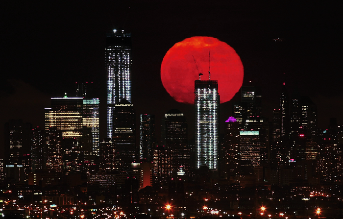 Red moon over New York City skyline at night
