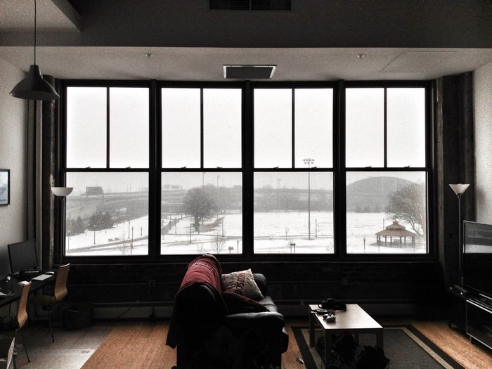 Apartment interior with large windows overlooking a snowy landscape