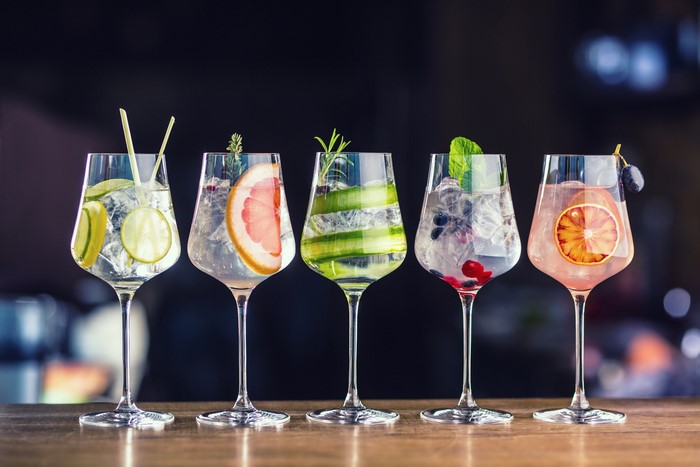 Five gin and tonic cocktails with garnishes