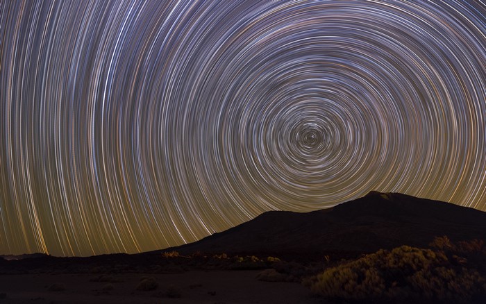 Star trails over a mountain landscape