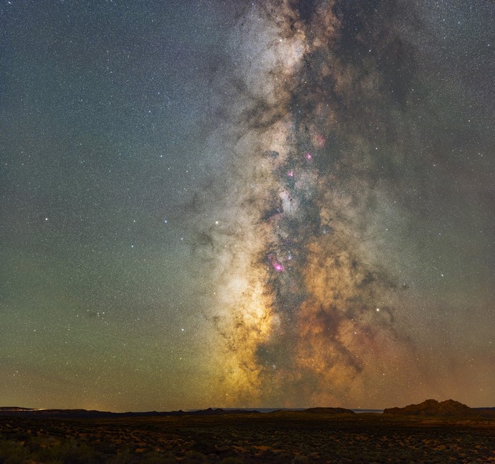 The Milky Way galaxy over a dark landscape