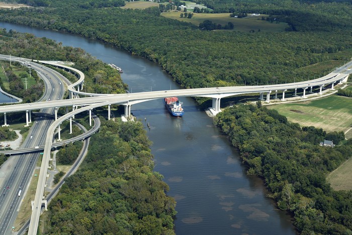 Ship passing under a highway bridge over a river in Virginia
