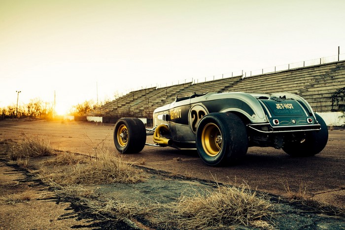 Hot rod car on a deserted racetrack at sunset