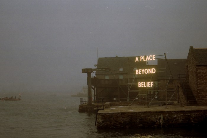 Artwork with text "A PLACE BEYOND BELIEF" in mist