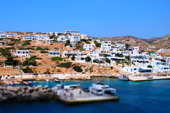 White buildings on a hillside overlooking a harbor in Greece