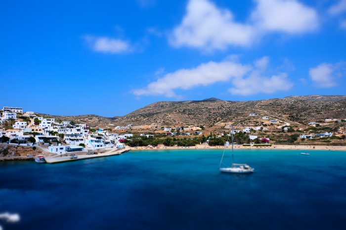 White village on the coast of Greece with a sailboat