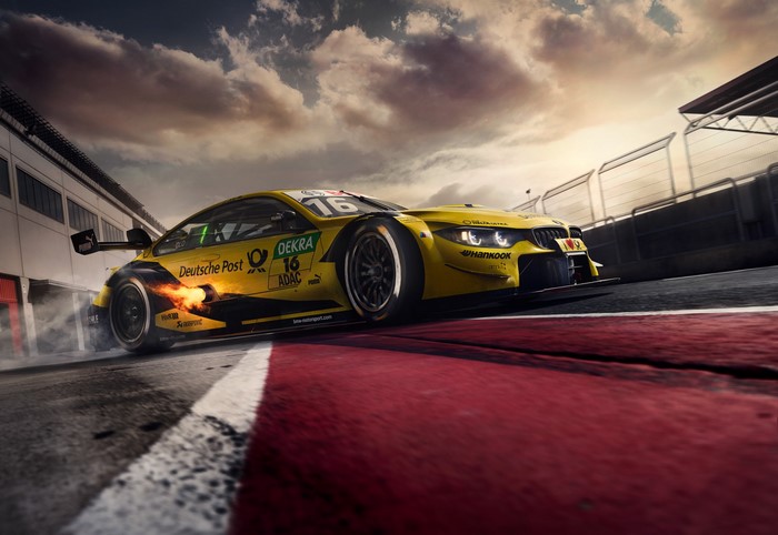 Yellow BMW race car with flames drifting on track