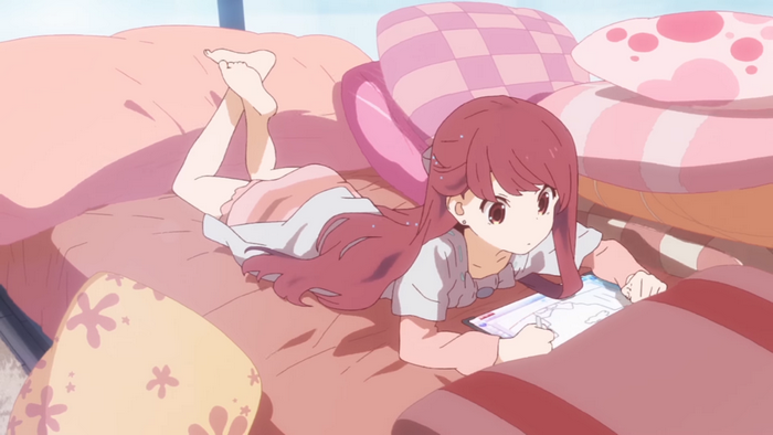 Girl with pink hair drawing on a tablet in bed