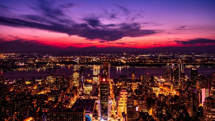 City skyline at dusk with purple and pink clouds
