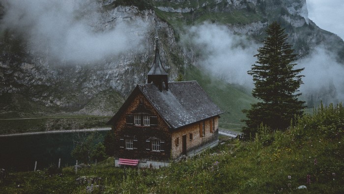 Wooden church by a lake in the Swiss Alps