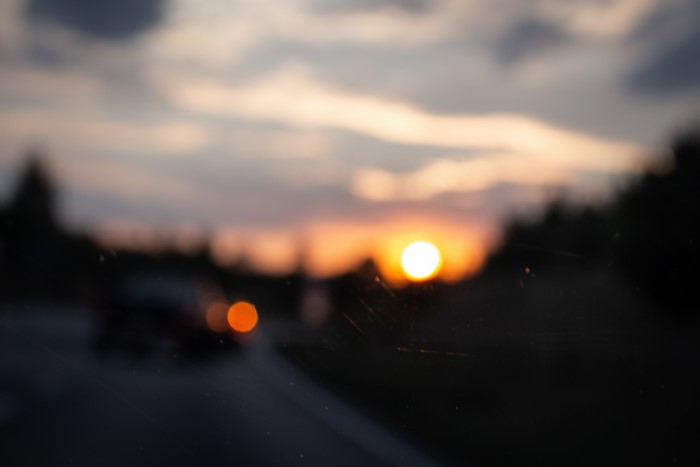 Blurred sunset over a road with car lights