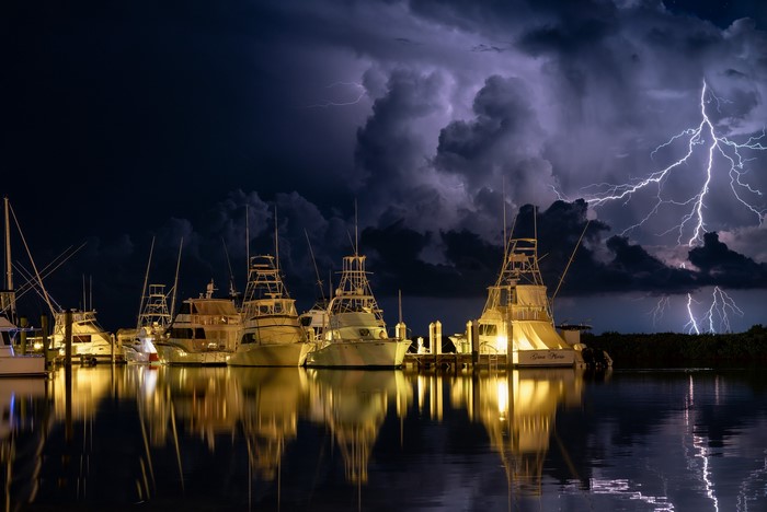 Boats docked during a lightning storm at night