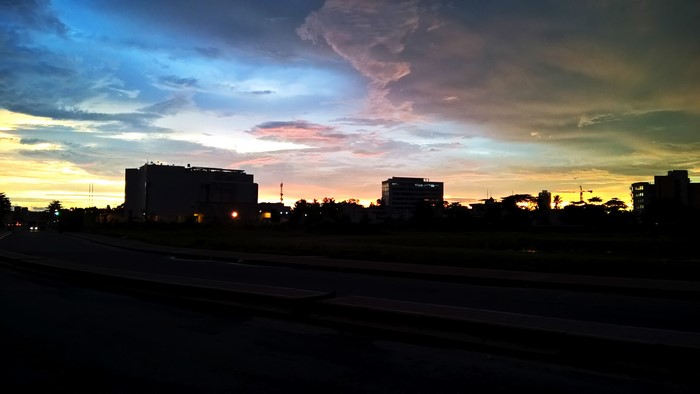 Buildings silhouetted against a colorful sunset sky