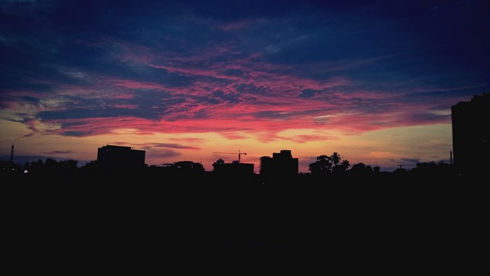 City skyline at sunset with colorful clouds