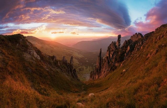Mountain valley at sunset with dramatic clouds